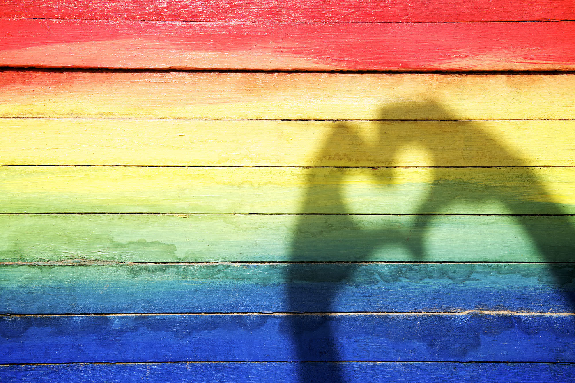 Hands Making Love Heart Shadow on Rainbow Background