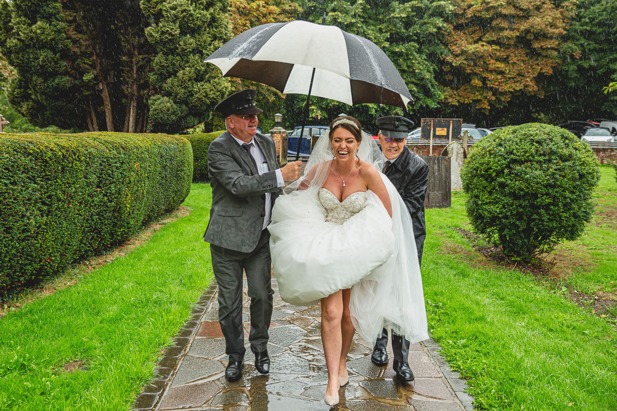 Bride running to the church through the rain